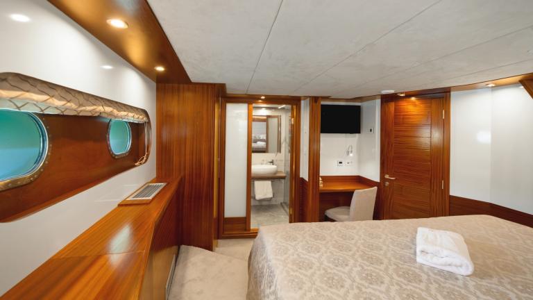 The good-sized cabin offers space for a double bed, built-in wardrobes, bathroom and a desk.